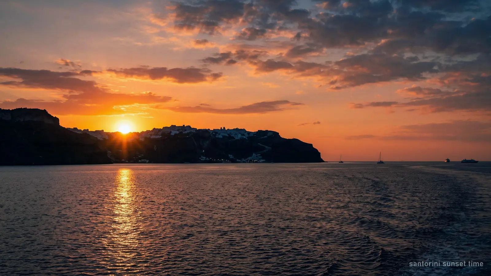 The sun touching the horizon west of Santorini, seen from the sea